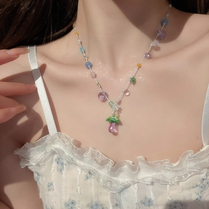 Détail d'un collier de perles colorées avec pendentif champignon porté sous la lumière