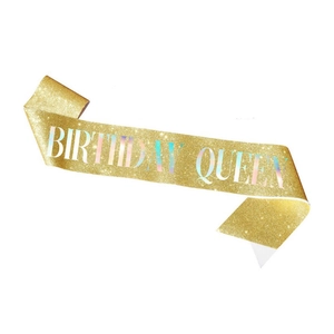 Close-up of glittery golden Birthday Queen sash with holographic laser lettering effect