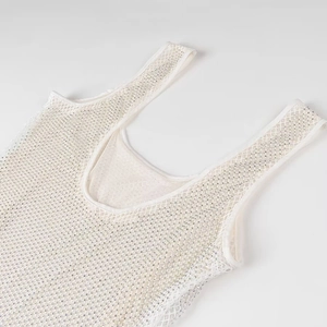 Détail du haut en maille blanc cassé avec des strass et perles scintillants