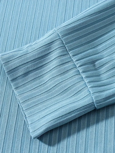 Detailed macro view of the light blue vertical rib-knit texture and cuff stitching details