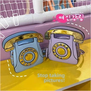 Detail of creative vintage telephone crossbody bags in blue and purple with dial pattern