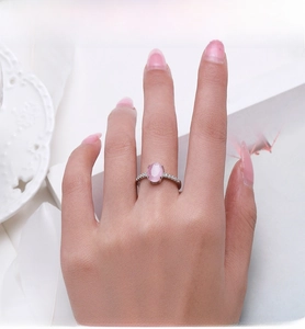 Detailed view of S925 silver ring featuring pink cat eye stone and pavé setting on finger