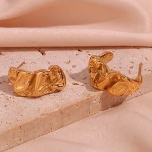 Macro detail of 18K gold plated earrings with irregular wrinkled texture on stone