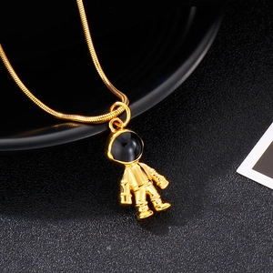 Detailed close-up of golden astronaut pendant on a fine snake chain necklace