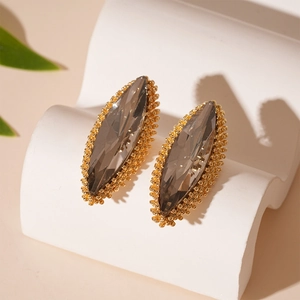 Detail view of marquise-cut smoky grey crystal earrings with gold textured edges