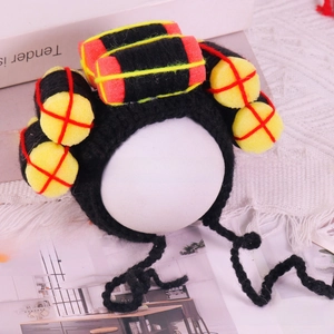 Macro view of a Chinese folk style knitted pet hat with colorful yellow and red sponge balls