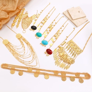 Nahaufnahme von goldenem Halsschmuck-Set im Ethno-Stil mit Münzen und Edelsteinen