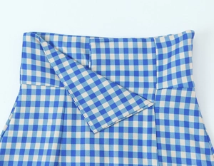 Detail of blue and white gingham skirt featuring a unique asymmetrical folded waistband