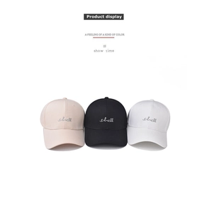 Detail of embroidered 'shell' script on washed cotton baseball caps in three classic colors
