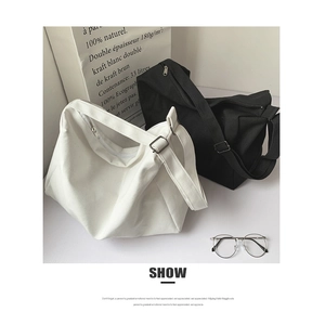 Detail showing high-capacity black and white canvas crossbody bags with thick texture