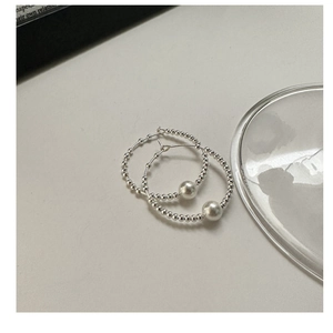 Macro view of S925 sterling silver beaded hoop earrings with large dangling pearls