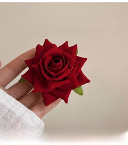 Detail of red velvet rose hair clip with retro French fairy style and rich petal texture
