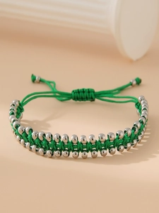 Détail du bracelet réglable en corde tressée verte avec perles en acier inoxydable poli