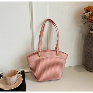 Pink striped tote bag with gold rings shown in a lifestyle setting on a desk