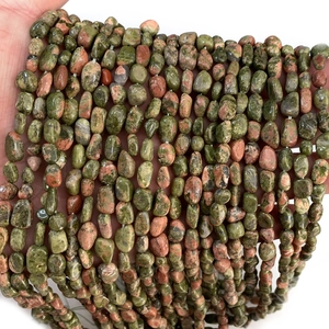 Detailed macro view of unakite natural stone chips with green and pink earthy textures