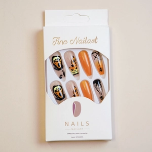 Detail of Halloween press-on nails featuring orange pumpkin faces and spider web designs
