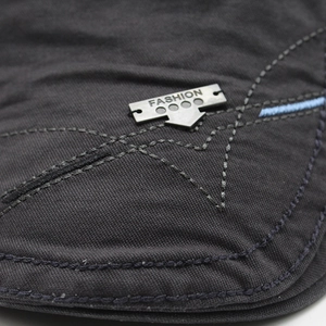 Detailed macro view of cotton fabric texture with silver metal badge and star stitching