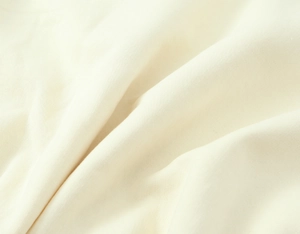 Dettaglio macro della trama in velluto crema e del materiale in maglia di alta qualità
