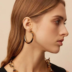 Close-up of tortoise shell resin C-shaped earrings and matching chunky link necklace