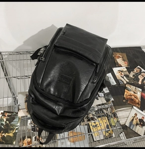 Dettaglio di uno zaino in pelle PU nera dal design minimalista su uno scaffale metallico