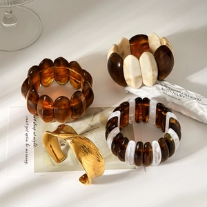 Artistic close-up of amber resin bracelets and a hammered gold metal bangle set