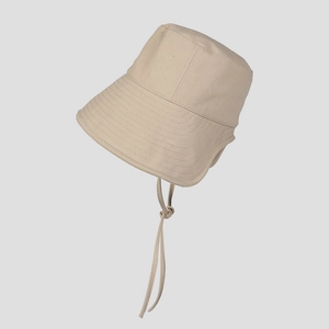 Detail of beige canvas bucket hat featuring durable fabric texture and adjustable chin strap