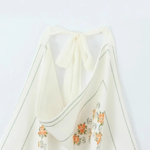 Off-white floral print halter top with orange blossoms and soft neck-tie details