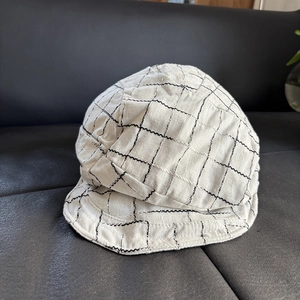 Detailed view of linen plaid newsboy cap with classic black and white checkered texture