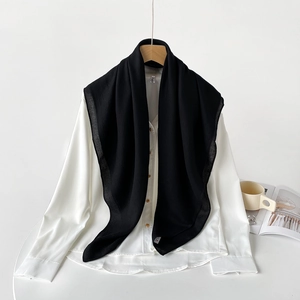 Close-up of black lightweight cotton linen scarf draped over a white minimalist shirt