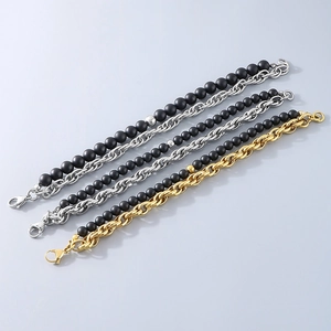Detail of stacked gold and silver metal link chains with black matte beads and lobster clasp