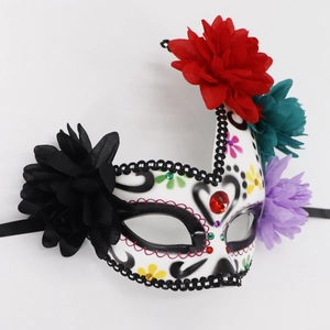 Detail of Day of the Dead mask with vibrant faux flowers, lace, and colorful rhinestones