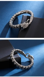 Makro-Detail von Schlangenarmband in Silberoptik mit weißen Kristallen auf Metallschuppen