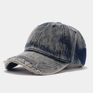 Close-up of distressed denim baseball cap with vintage frayed edges and washed finish
