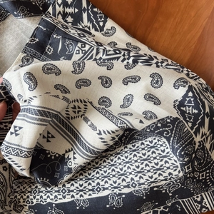 Gros plan d'un imprimé cachemire bohème noir et blanc sur fond de tissu en lin texturé