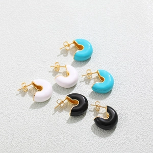 Dettaglio di tre paia di orecchini a cerchio in smalto colorato blu, bianco e nero a forma di C