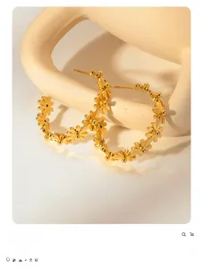 Detailed view of vintage gold flower hoop earrings with intricate floral patterns
