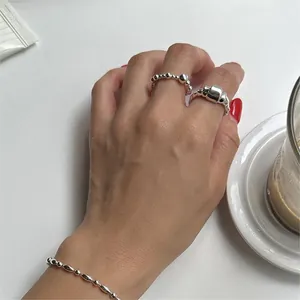 Close-up of a 925 sterling silver beaded bracelet and textured irregular open ring