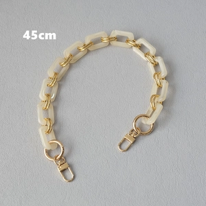 Dettaglio della tracolla da 45cm in resina crema e maglie dorate per borse e cellulari