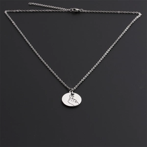 Détail macro d'un collier en acier inoxydable argenté avec pendentif geste du coeur