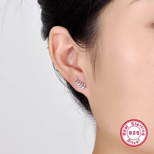 Macro shot of S925 sterling silver leaf stud earring with white zircon inlay on model