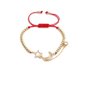 Detail of red woven adjustable bracelet with gold beads and moon star zircon charms
