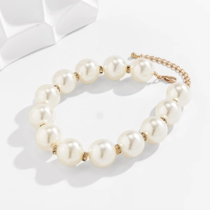 Detailed macro of oversized faux pearl bracelet with sparkling rhinestone spacers