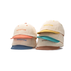 Détail de cinq casquettes bébé colorées avec broderie tomorrow et visière souple