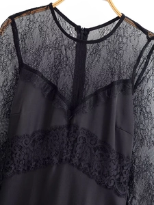 Detail of elegant black long sleeve dress featuring sheer lace neckline and hidden zipper