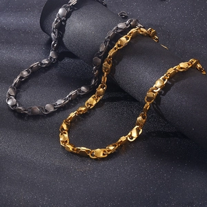 Detail view of gold and dark grey geometric titanium steel chain links on black background