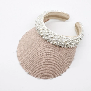 Detail of woven straw sun visor with faux pearl embellishments and pink braided texture