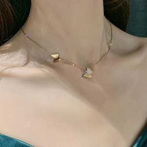Elegante collana con due farfalle dorate in acciaio inossidabile indossata da donna