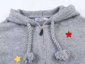 Detail of grey knitted hoodie showing zip, braided drawstrings and star embroidery