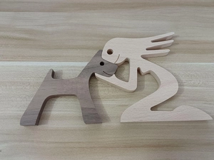 Close-up of handcrafted wooden sculpture showing a person hugging a small dog