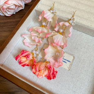 Gros plan de boucles d'oreilles fleurs en tissu rose avec perles et cristaux fins
